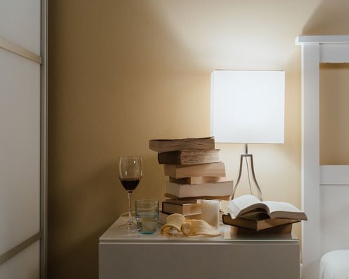 A lamp shedding warm light on a book resting on a wooden table
